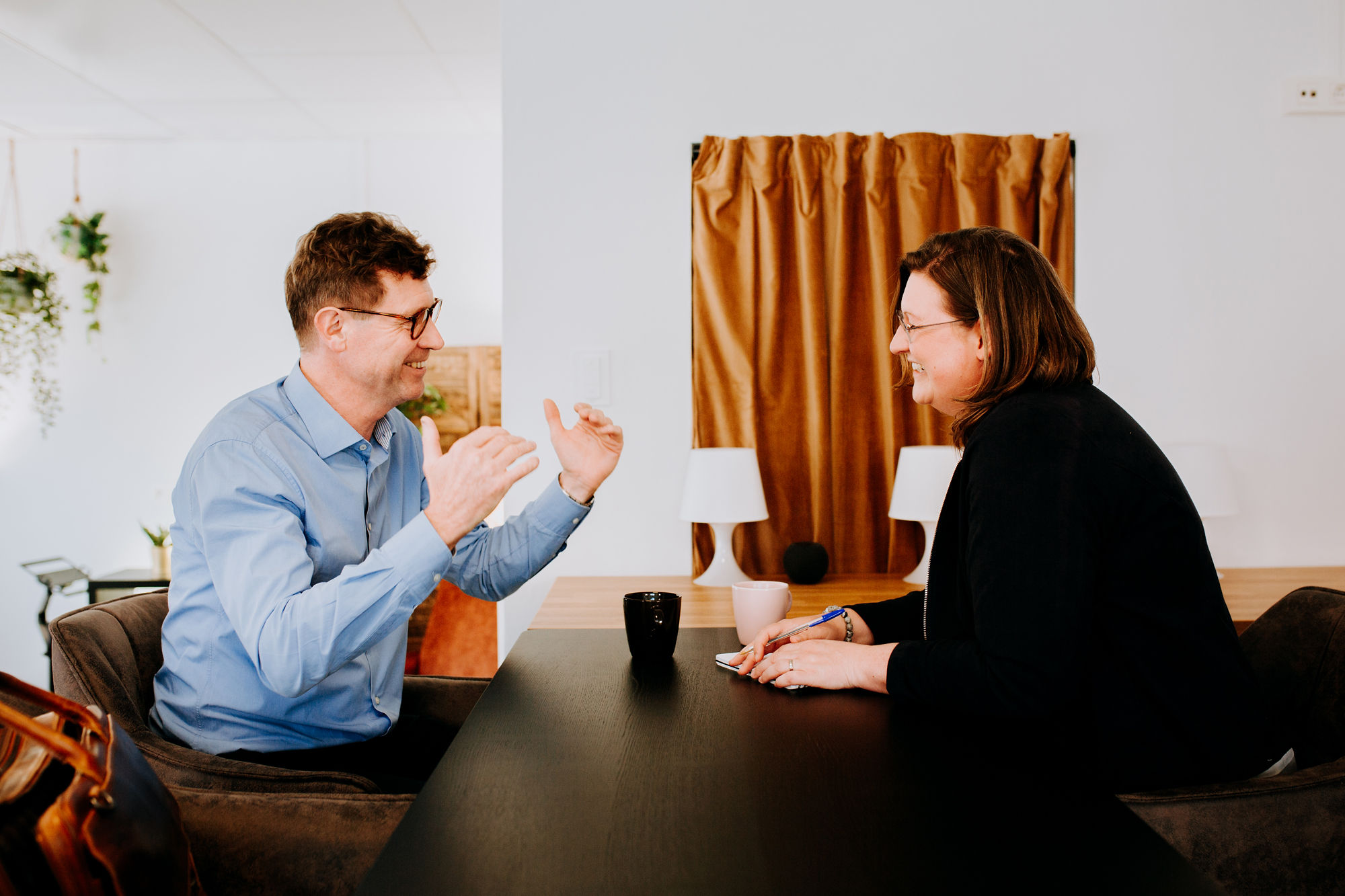 Ellen Bracquine sitting with a client for presentation coaching